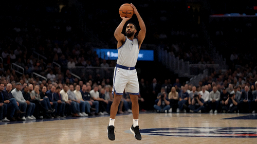 NBA篮球场内球员跳起投篮的瞬间，观众席模糊背景展现赛场氛围